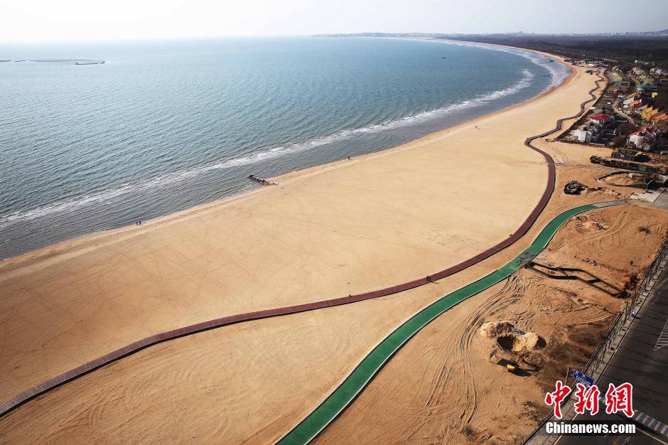 3月13日，秦皇島萬(wàn)米臨海沙灘木棧道。據(jù)了解，該木棧道全長(zhǎng)約4200米，與北戴河區(qū)原有的7500米木棧道對(duì)接后全線總長(zhǎng)度1.17萬(wàn)米，整個(gè)木棧道東起秦皇島體育基地游船碼頭，西至北戴河濕地公園，呈波浪形蜿蜒10.4公里海岸線。 中新社發(fā) 曹建雄 攝 CNSPHOTO