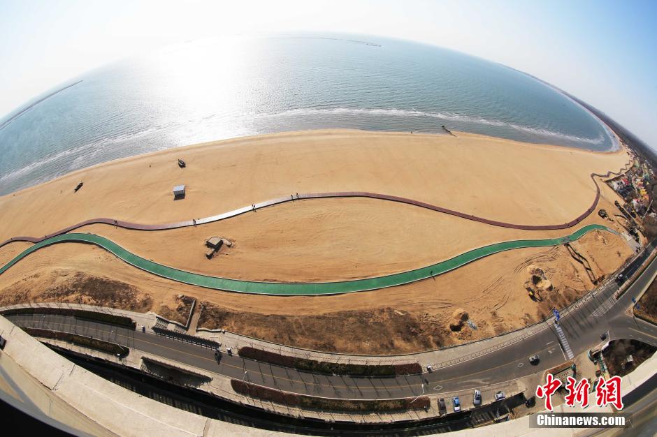 3月13日，秦皇島萬(wàn)米臨海沙灘木棧道。據(jù)了解，該木棧道全長(zhǎng)約4200米，與北戴河區(qū)原有的7500米木棧道對(duì)接后全線總長(zhǎng)度1.17萬(wàn)米，整個(gè)木棧道東起秦皇島體育基地游船碼頭，西至北戴河濕地公園，呈波浪形蜿蜒10.4公里海岸線。 中新社發(fā) 曹建雄 攝 CNSPHOTO